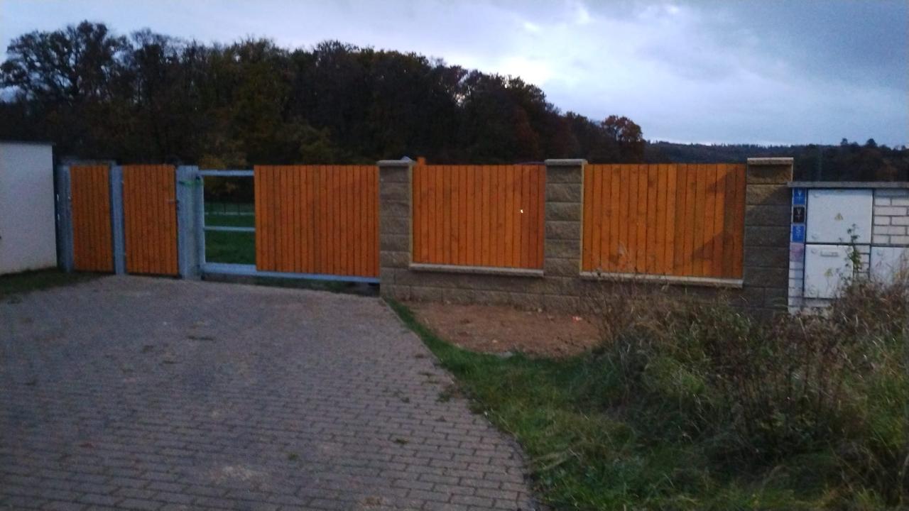 Hotový dřevěný plot s brankou a bránou u vjezdu – po