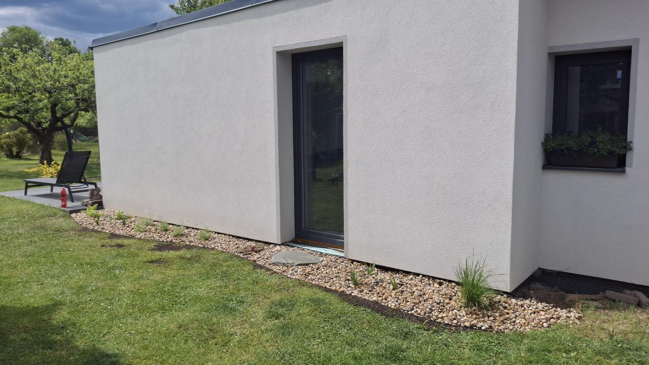 Hotový okapový chodník z kačírku s výsadbou – po