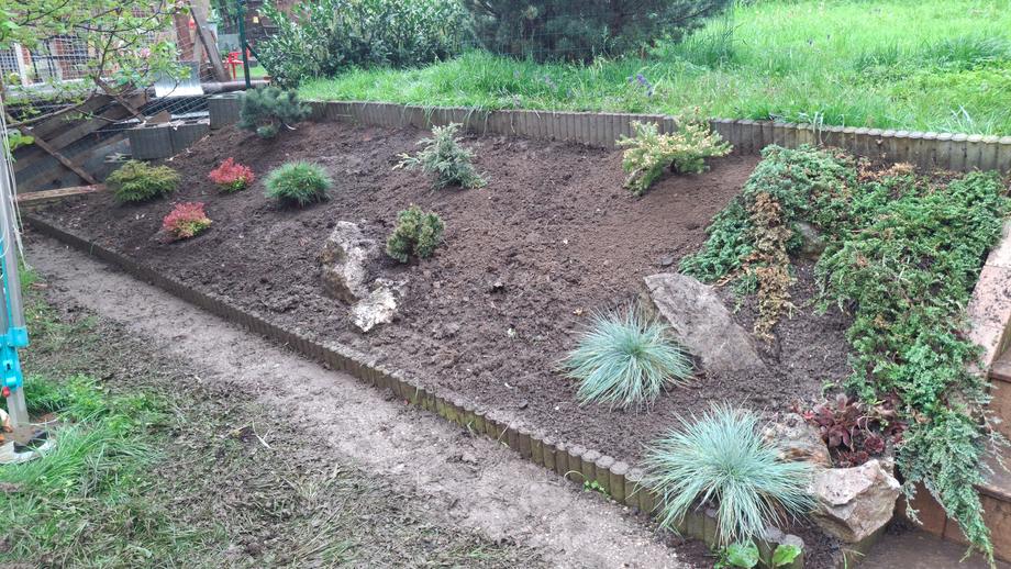 Vypletý svah záhonu s okrasnými travinami a jehličnany – Drobná řemesla