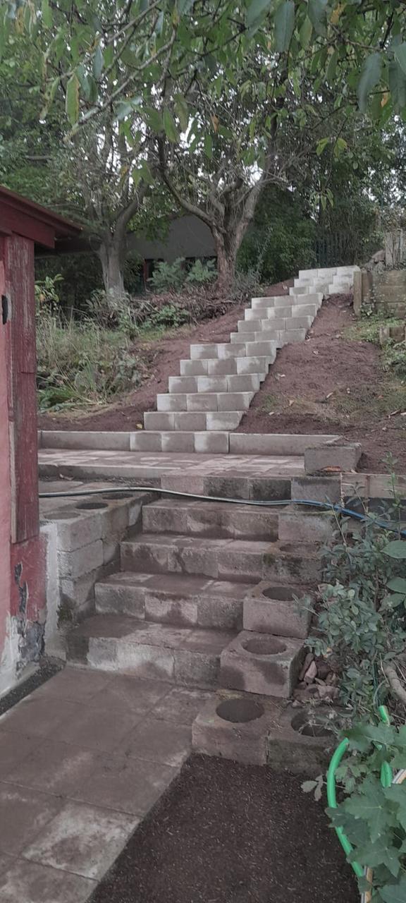 Nové betonové schody a dlážděná plocha ve svahu – po